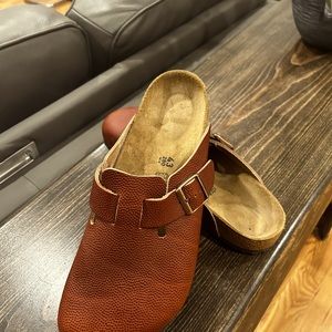 A cool pair of Birkenstock tan leather slip on .